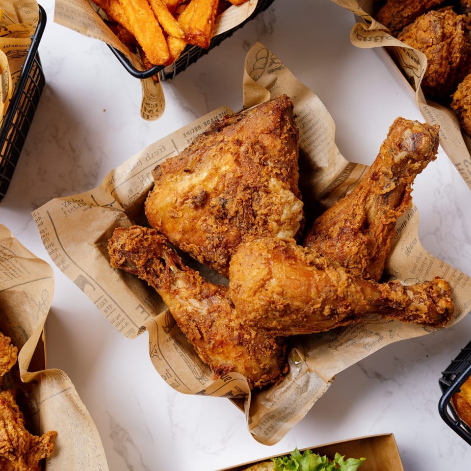 Crispy fried chicken pieces from Hip Hop Fish & Chicken, served in a paper-lined basket with fries.